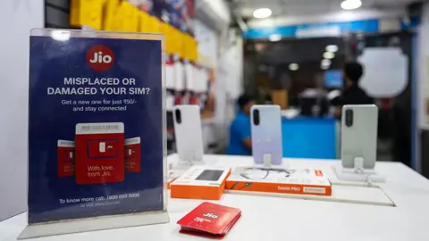 Bloomberg via Getty Images An information sign for sim cards at a Reliance Jio Infocomm Ltd. store, a subsidiary of Jio Platform Ltd., in New Delhi, India, on Thursday, Nov. 6, 2025. I