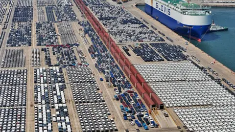 Getty Images Export cars are gathered at a commodity vehicle roll on/roll off terminal waiting to be loaded onto a ship in Yantai, Shandong, China on May 11, 2026