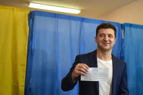Getty Images Mr Zelensky shows his ballot to the media at a polling station during the second round of Ukraine's presidential election in Kyiv in April 2019
