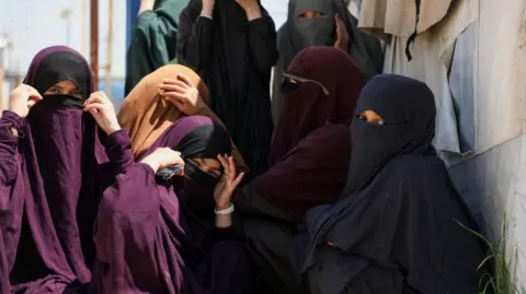 Reuters A groups of Australian girls in a Syrian camp in head coverings look at the camera