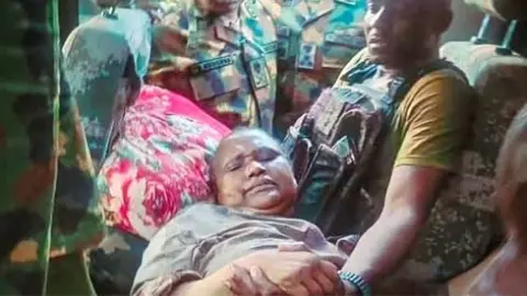 Nigeria Defence Headquarters Nigerian Military officers surround Mrs Rabe Abubakar who was rescued after weeks in captivity