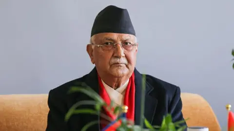 Getty Images A man wearing a black suit and black hat looks at the camera