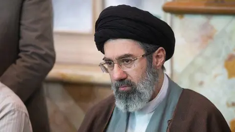 Tasnim News Agency Mojtaba Khamenei, with a black turban and a brown robe, looks away from the camera