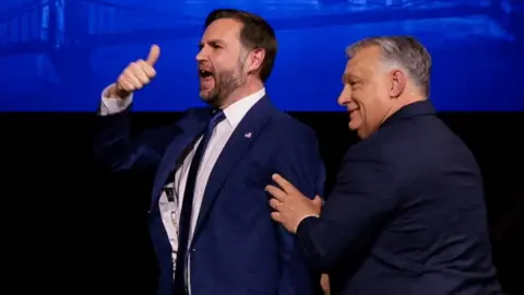 Reuters A man holds his thumb in the air while another man pushes him in the back from the right