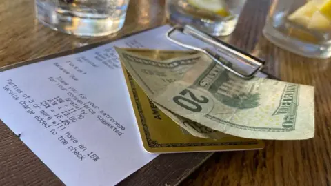 AFP via Getty Images A $20 dollar cash tip left on the bill at a US restaurant