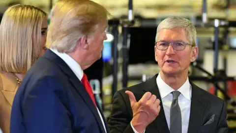 AFP/Getty US President Donald Trump stands on the left and Apple CEO Tim Cook stands on the right as they talk during a tour the Flextronics computer manufacturing facility where Apple's Mac Pros are assembled in Austin, Texas.