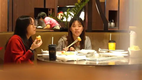 Two female diners eating hotpot at a Haidilao outlet in Singapore.