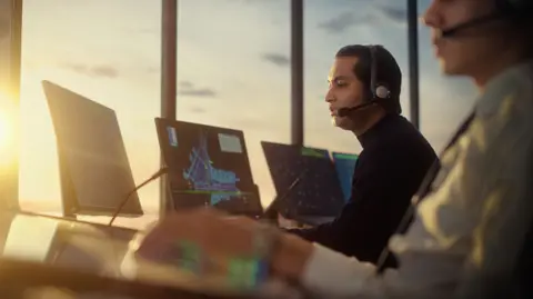 Getty Images Stock image of a male air traffic controller with headset in airport tower. 