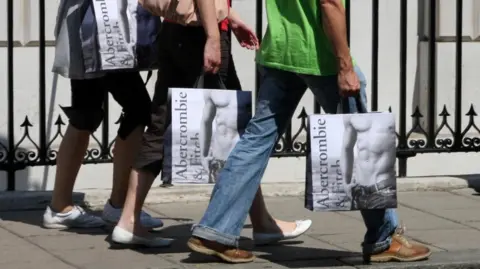 People carrying Abercrombie & Fitch shopping bags walking on a street