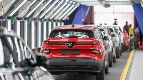 Bloomberg via Getty Images A row of cars at Vietnamese electric vehicle maker VinFast's new factory in South India. 