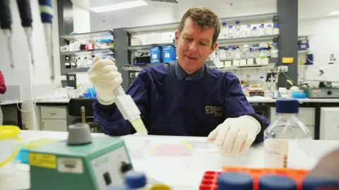 Getty Images Professor Ian Frazer working with lab equipment