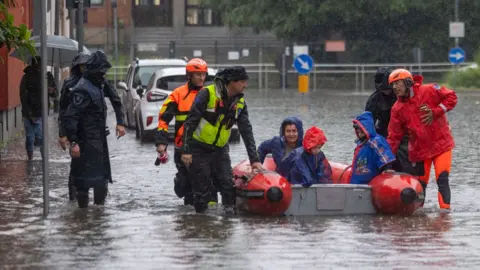  LaPresse/REX/Shutterstock Firefighters evacuating people near Milan 