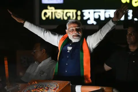 Hindustan Times via Getty Images Prime Minister Narendra Modi during a road show in support of BJP candidates ahead of 2nd phase of West Bengal Assembly Election 