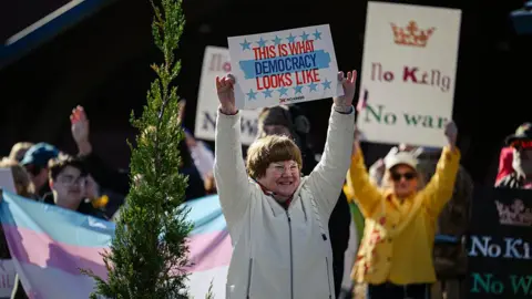 Getty Images A woman holds a sign reading "this is what democracy looks like" during a protest in Kentucky