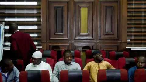 Reuters The five men sitting on red and black chairs in court