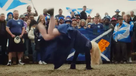 Irn-Bru Scotland fans, aka the Tartan Army, with Susan Boyle breakdancing in front of them