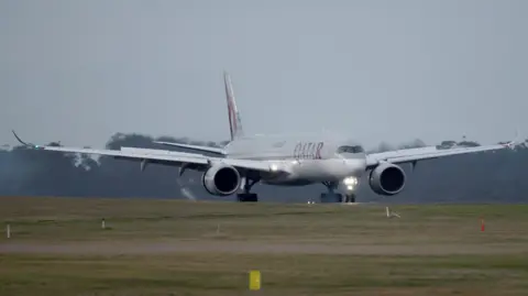 Getty Images A Qatar Airways flight carrying families linked to IS lands in Melbourne