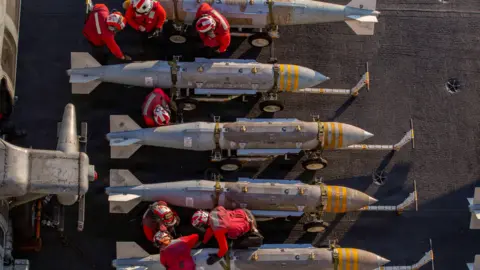 US Navy via Getty Images US sailors prepare to stage ordnance on the flight deck of Nimitz-class aircraft carrier USS Abraham Lincoln