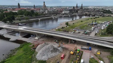 Getty Images Bridge over the Elbe River under construction. In the background across the river is the city centre, including the Frauenkirche and other landmarks.