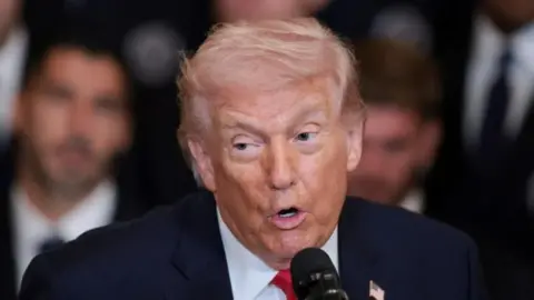 Reuters US President Donald Trump speaking into a microphone