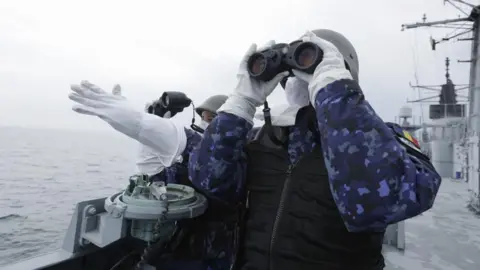 EPA Two Romanian navy officers from the Romanian Navy frigate 'King Ferdinand' monitor the target for a canon live fire shooting during the NATO naval drill 'Sea Shield 26' in the Black Sea