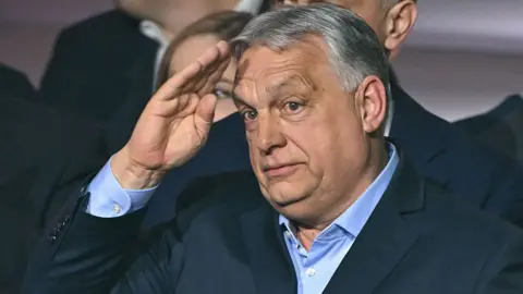 Attila Kisbenedek via Getty Images Hungarian Prime Minister Viktor Orbán salutes the crowd after losing the general election on 12 April 2026.