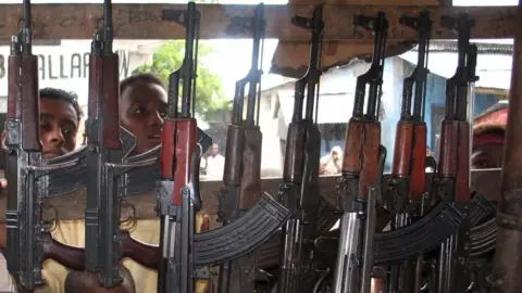 MCT/Getty Images Young men and boys stare into a market stall selling automatic weapons in Mogadishu in 2006