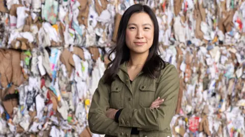 Glacier Rebecca Hu-Thrams stands with her arms folded wearing a green jacket