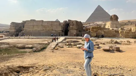 Eman Ghoneim/UNCW UNCW Professor Eman Ghoneim studies the surface topography of the section of the ancient Ahramat branch located in front of the Pyramids of Giza and the Great Sphinx. Photo Credit: Eman Ghoneim/UNCW