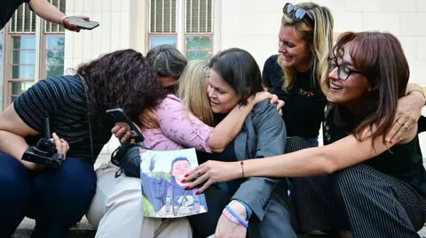 AFP via Getty Images A plaintiffs' attorney for the Social Media Victims Law Center embracing family members of victims on the steps outside the Los Angeles Superior Court on Wednesday.