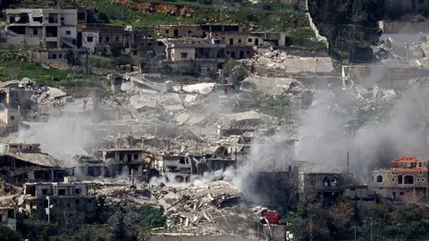 AFP via Getty Images Smoke rises from bombed out buildings. 
