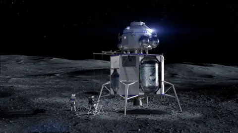 Blue Origin A tall, spindly spacecraft stands alone on a bleak grey plain under a black, star‑filled sky. This is Blue Origin’s Blue Moon lander: a white, boxy lower stage on four delicate legs, topped by a rounded cabin like a silver lighthouse. Bulging metallic tanks cling to its sides, catching harsh moonlight. A small ladder unfolds to the dust, where two astronauts in chunky white suits work beside scientific gear, their shadows stretching long across the cratered surface. The surrounding landscape is empty, rolling gently away into darkness, emphasising how exposed and futuristic this gleaming machine appears.