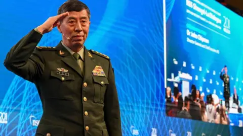 AFP via Getty Images Li Shangfu salutes the audience before delivering a speech during the 20th Shangri-La Dialogue summit in Singapore on June 4, 2023