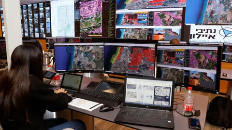 AFP Air traffic controllers monitor control screens during a press presentation as part of the National Drone Initiative test operation at the Drone Air Control Centre in the Israeli coastal city of Tel Aviv, on October 11, 2021.