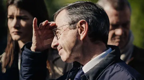 AFP via Getty Images A man looks into the sun with his hand to his face