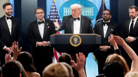 Reuters U.S. President Donald Trump speaks next to Federal Bureau of Investigation (FBI) Director Kash Patel, acting Attorney General Todd Blanche, Vice President JD Vance and Homeland Security Secretary Markwayne Mullin at a press briefing at the White House, following a shooting incident during the annual White House Correspondents’ Association dinner, in Washington, D.C.,