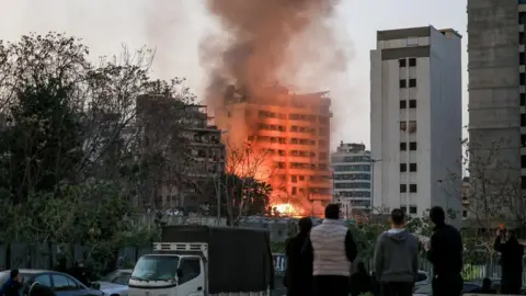 Reuters Smoke and flames rise following an Israeli strike in central Beirut's Bachoura neighbourhood, Lebanon (12 March 2026)