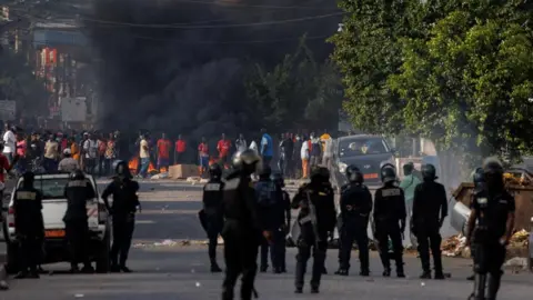 Reuters Riot police stand as a large plume of smoke rises near supporters