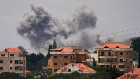 Reuters Large plumes of smoke rise above buildings in Nabatieh, southern Lebanon, after Israeli air strikes on 25 May 2026