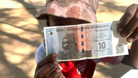 Farai Sevenzo A child holding up one of the first Zig notes to go into circulation - Friday 3 May 2024