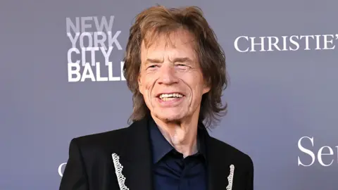 Getty Images Mid-shot of Sir Mick Jagger, wearing a lace lapelled suit jacket