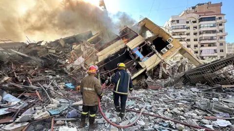 Reuters Members of the Lebanese Civil Defence inspect a damaged building after an Israeli strike on Beirut's southern suburbs, Lebanon (9 March 2026)
