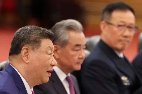 Reuters Chinese President Xi Jinping, seated next to China’s Foreign Minister Wang Yi, attends a bilateral meeting with U.S. President Donald Trump (not pictured) at the Great Hall of the People, in Beijing, China May 14, 2026.