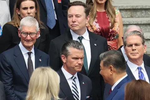 EPA Apple CEO Tim Cook (L), Tesla CEO Elon Musk (C), U.S. Defense Secretary Pete Hegseth (3-R) and U.S. Treasury Secretary Scott Bessent (R) attend the welcome ceremony for U.S. President Donald Trump by Chinese President Xi Jinping, at the Great Hall of the People in Beijing, China, 14 May 2026. 