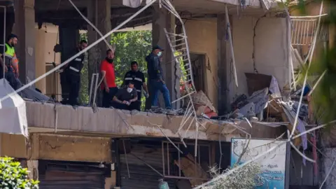 Reuters Police officers and emergency personnel work at the site of an Israeli strike on Beirut's southern suburb of Dahieh, Lebanon. Photo: 14 June 2026