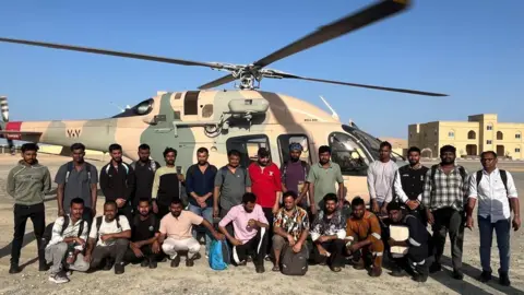 Forward Seamen's Union of India/x.com/FSUIINDIA A group of Indian seafarers pose in front of a helicopter.