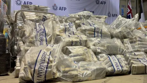 Australian Federal Police A pile of large plastic bags containing dozens of packages and bearing the label of Australian Federal Police