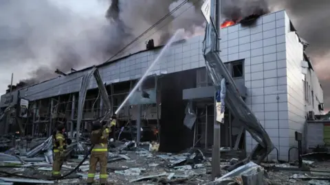 Reuters Firefighters work at a car dealership damaged during Russian missile and drone strikes, amid Russia's attack on Ukraine on 2 June.