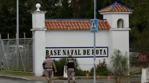 Getty Images Two soldiers walk towards the naval base of Rota