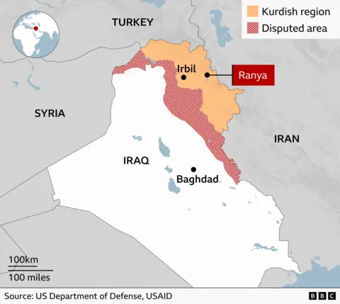 A BBC map of Iraq showing the Kurdish region in the north of the country which lies between the borders with Turkey and Iran. The entire border with Turkey is under Kurdish control. To the south of this Kurdish region is an area of roughly equal size over which political control is disputed. A rough visual estimate would suggest that these two areas combined comprise around 15% of the total area of Iraq. Around 100km of the border with Syria lies along the west of the disputed area. In the East, control of around 200km of the border with Iran is being disputed, with the border to the north – making up around a third of the total Iranian border – being under Kurdish control. The Kurdish regional capital of Erbil is shown and the town of Ranya is highlighted 100km to the East. The source for the borders of the Kurdish region and disputed area is the US Department of Defense and USAID.
